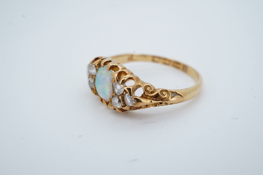 A late Victorian 18ct gold and oval white opal ring with six stone diamond set shoulders, size J, hallmarked for Birmingham, 1899, gross weight 2.5 grams. Condition - poor to fair